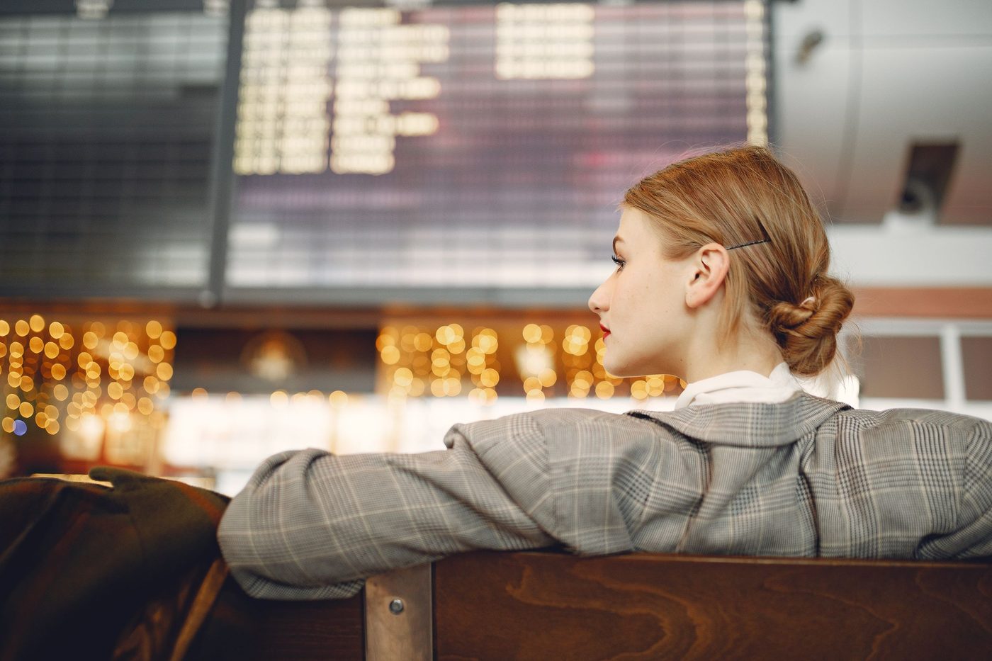 A traveller waiting by an airport window at golden hour