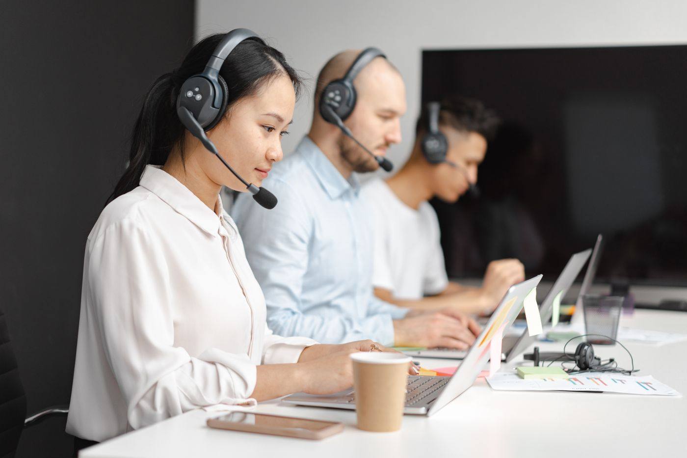 A support agent at a desk wearing a headset