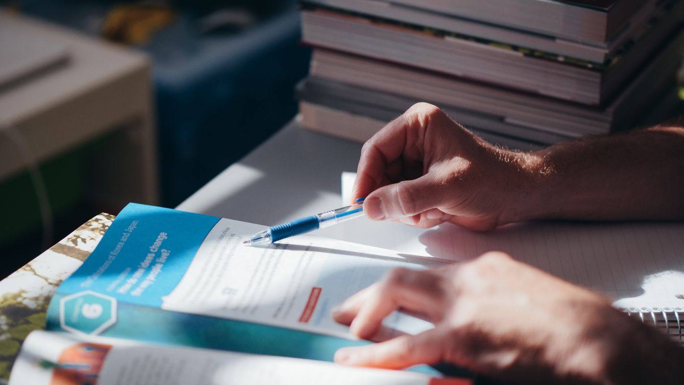 Hands drafting a letter at a desk