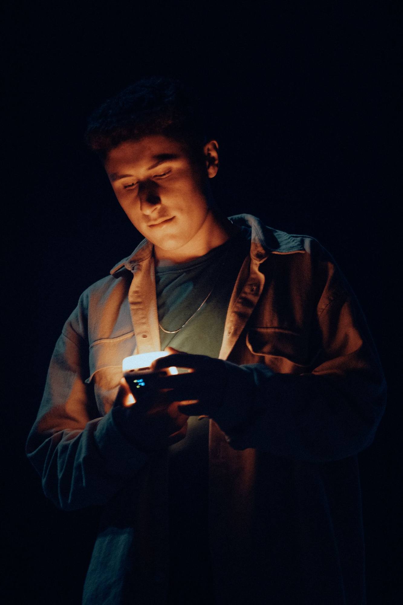 A face lit only by a phone screen in the dark