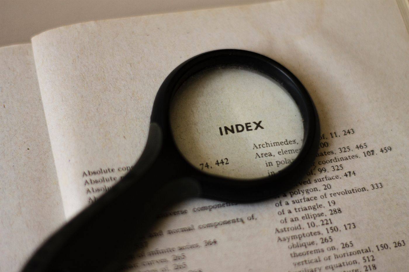 A magnifying glass resting on a book index